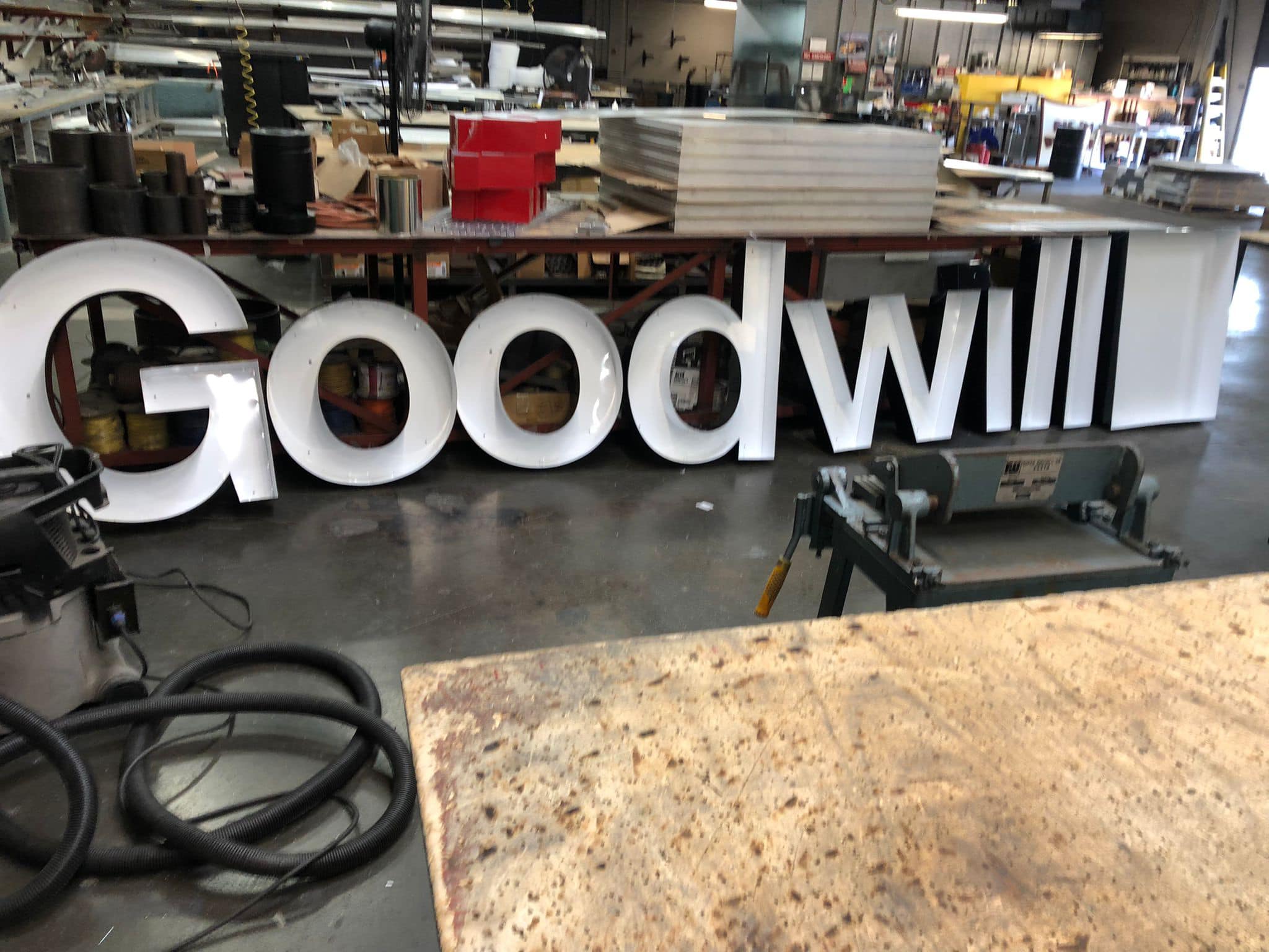 Large "Goodwill" sign in workshop setting.