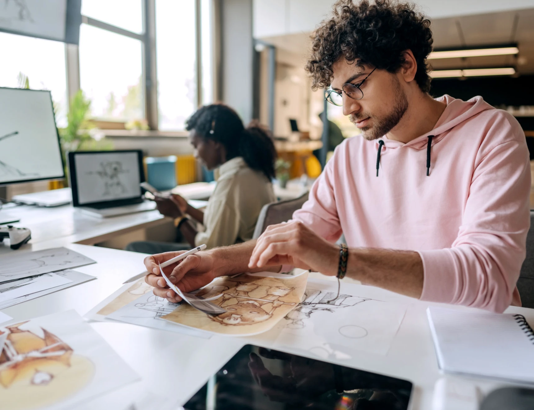Man working on illustrations at desk.