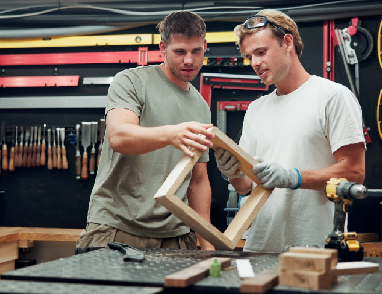 Two men working on a wooden frame.