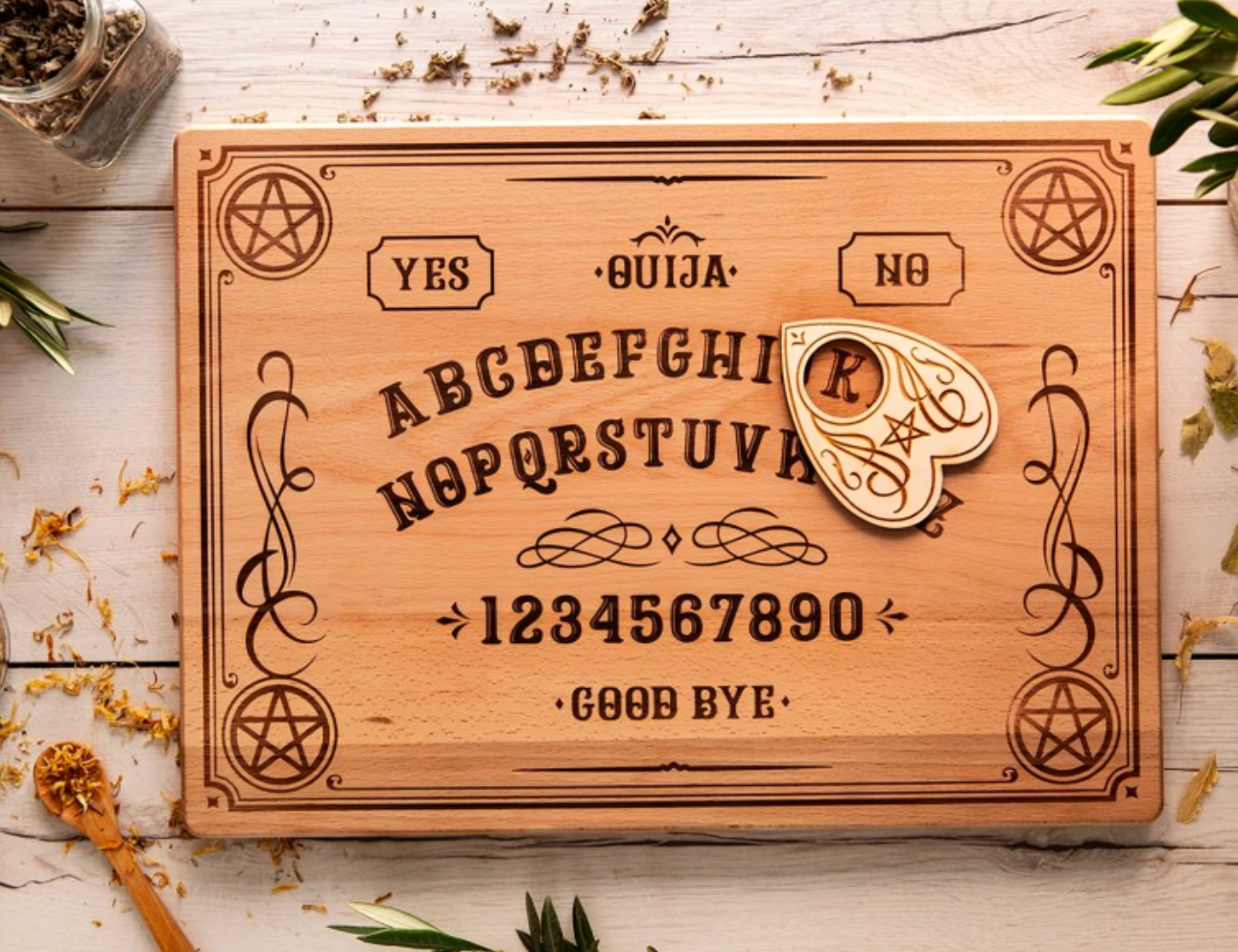 Ouija board with planchette on wooden table.