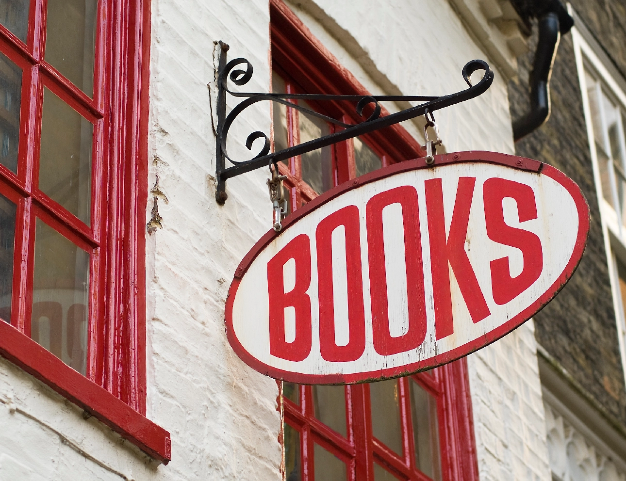 Red bookshop sign on building exterior.