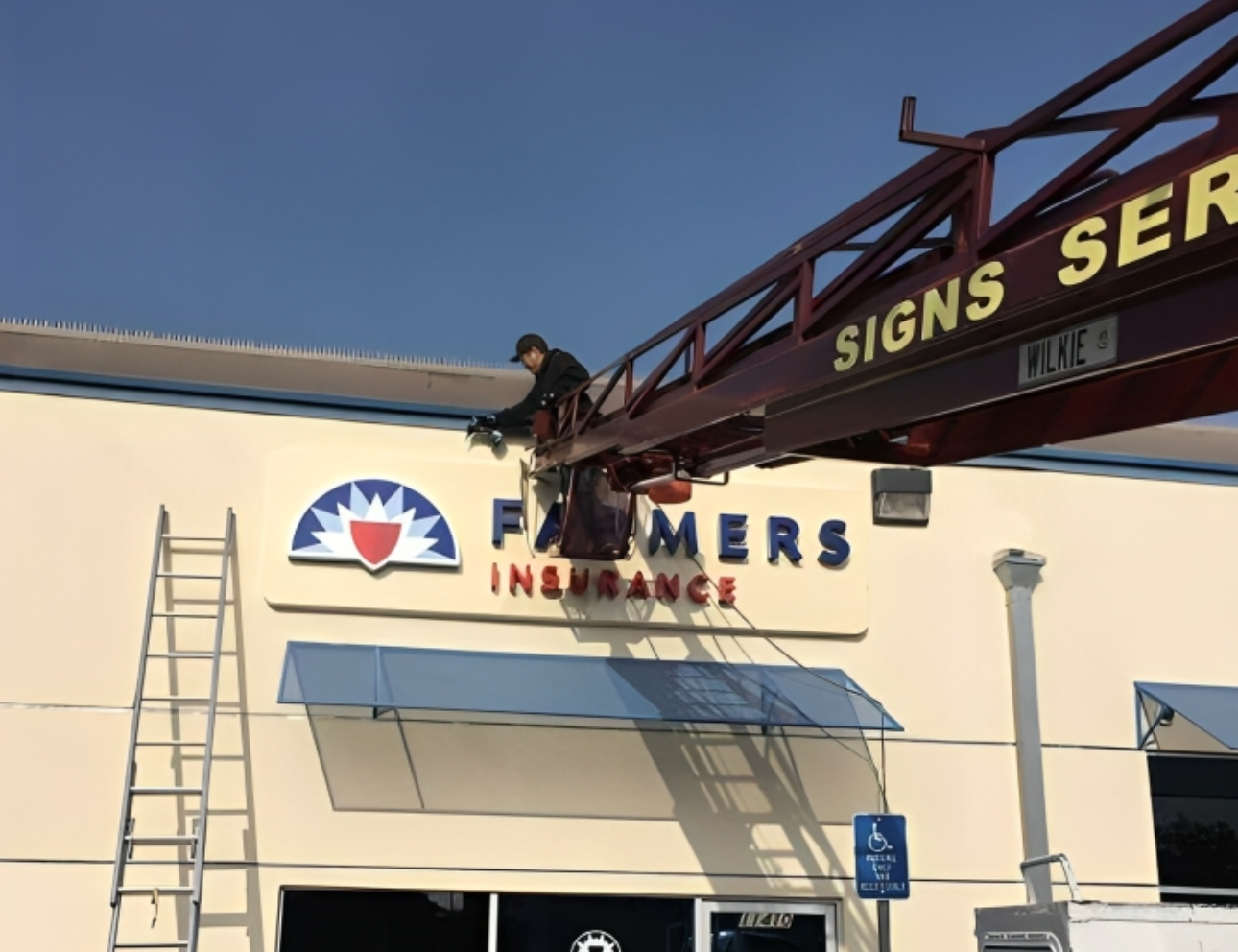 Installing Farmers Insurance sign on building.