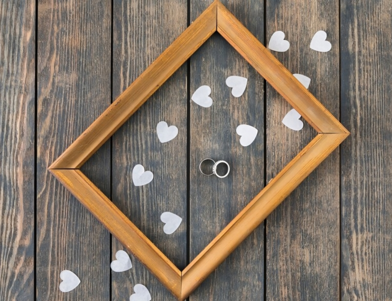 Wooden frame with rings and paper hearts.