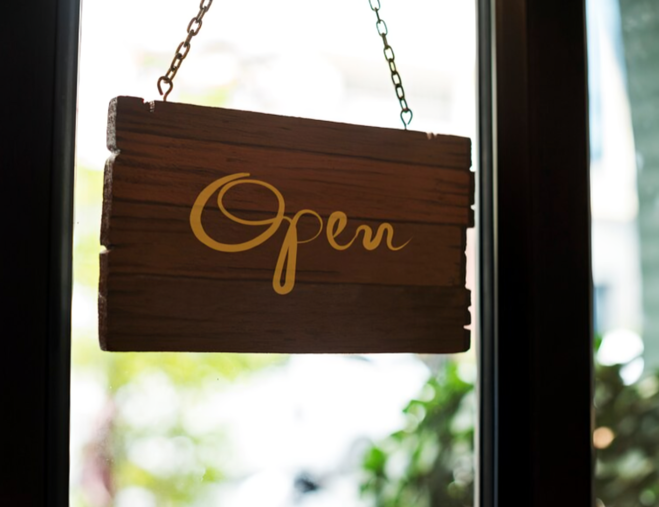 Wooden sign with "Open" in yellow script.
