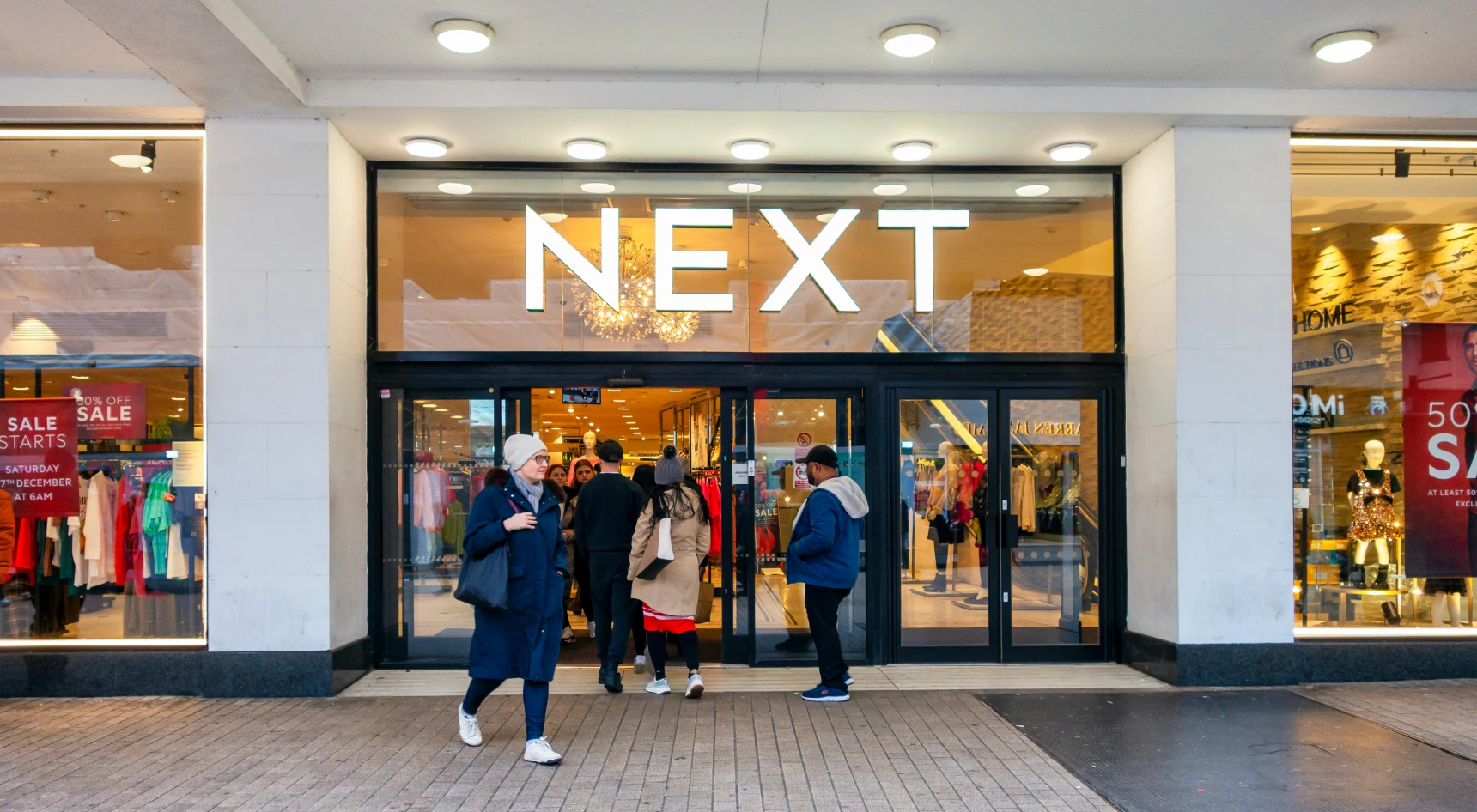 Shoppers entering a Next clothing store.