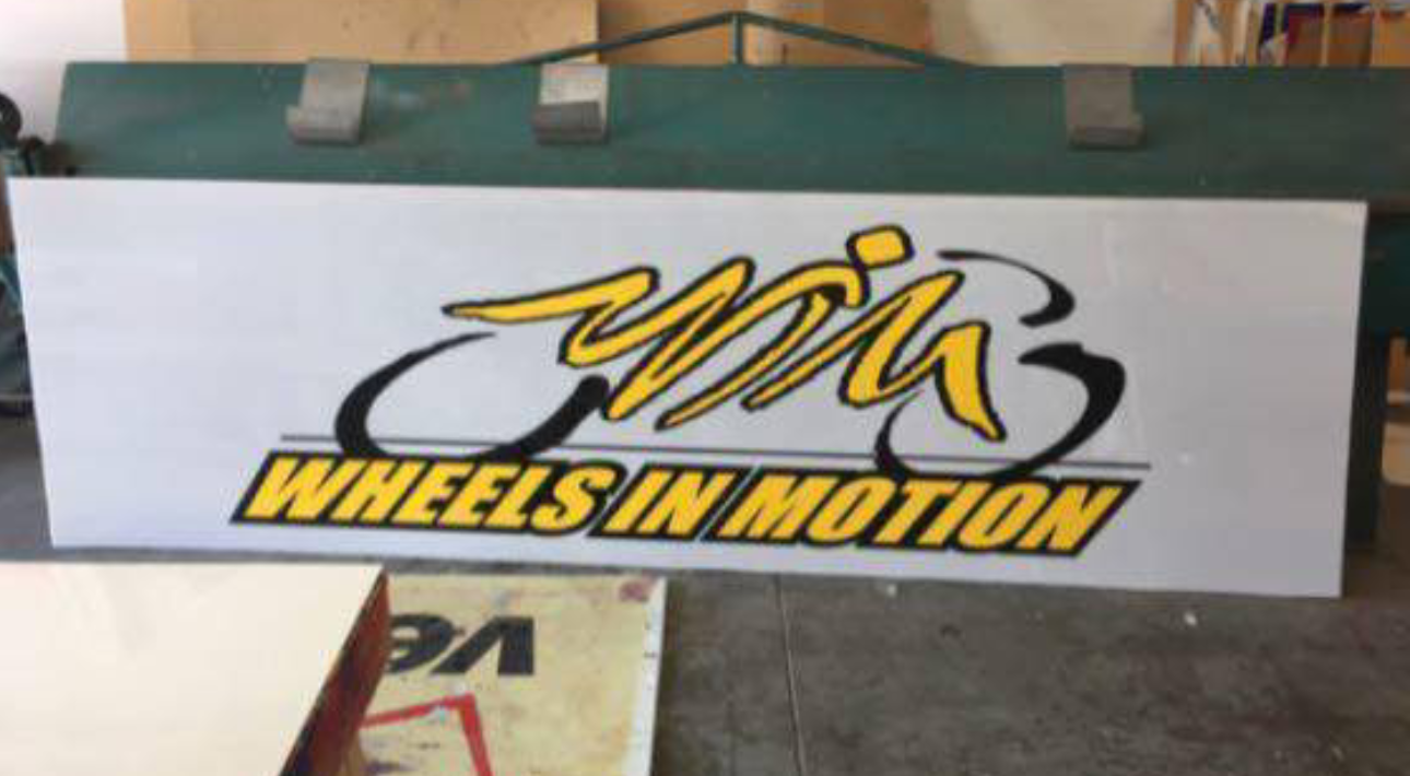 Logo reading "Wheels in Motion" on board.