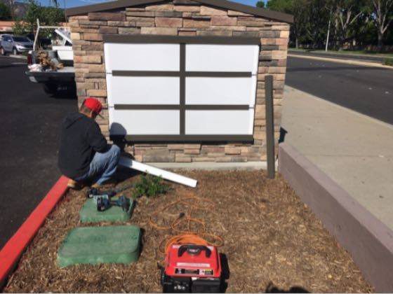 Person working on outdoor sign installation.
