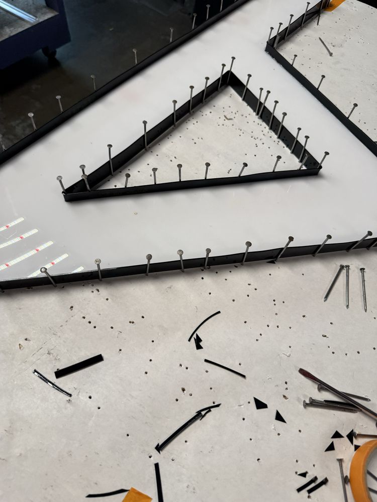 Triangle-shaped sign in construction with nails.
