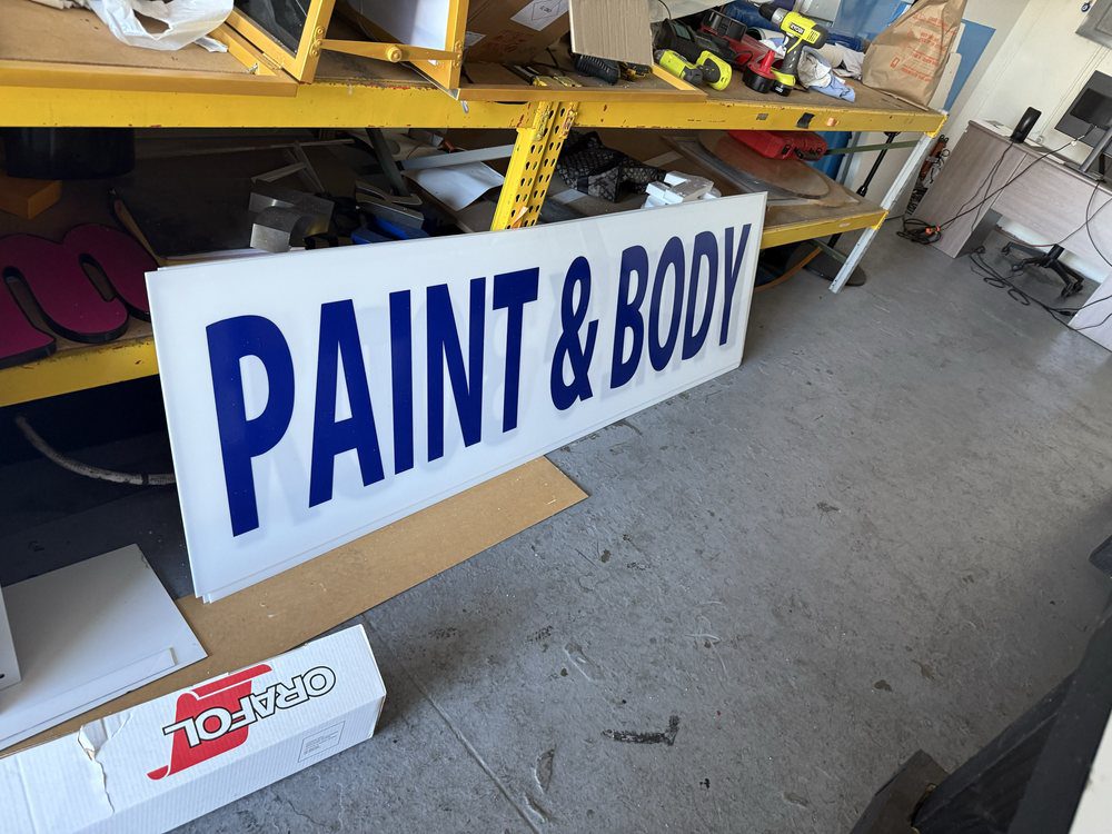 Paint & Body sign in workshop setting.