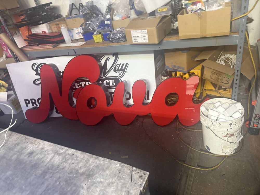 Red "Nova" sign in cluttered workshop.