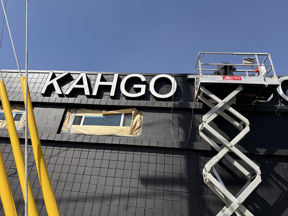 Building sign installation with crane lift.