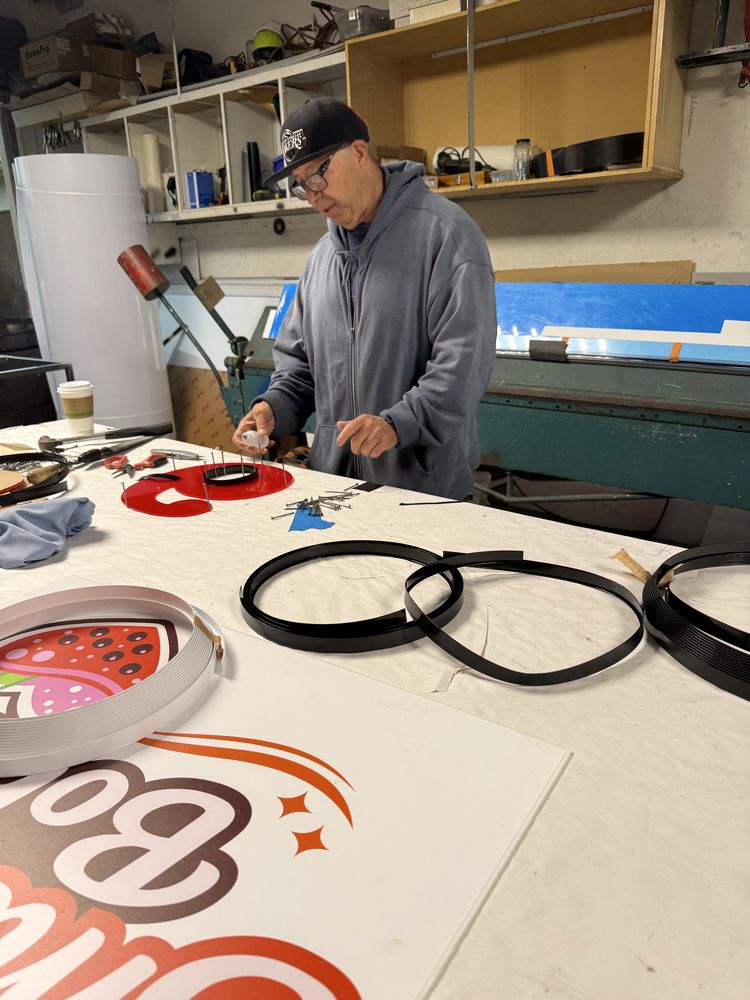 Man working on sign in workshop.