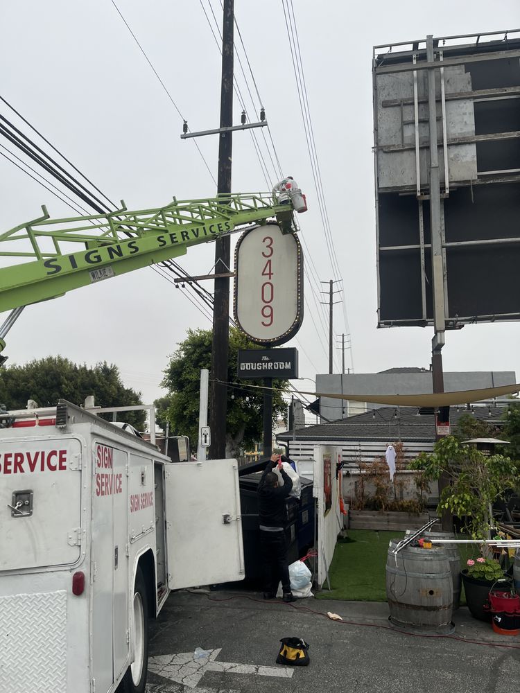 Sign installation with service truck and crane.
