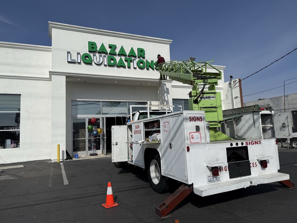 Sign installation at Bazaar Liquidation store facade.