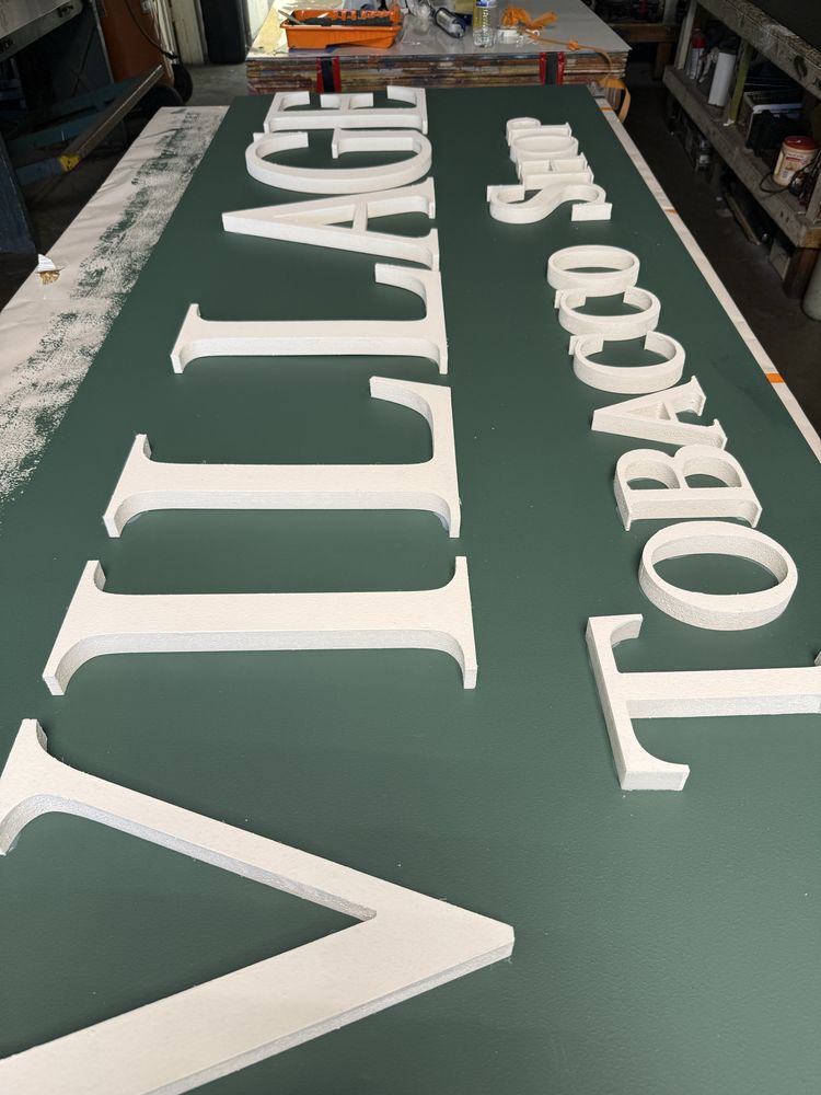 White letters on green sign in workshop.