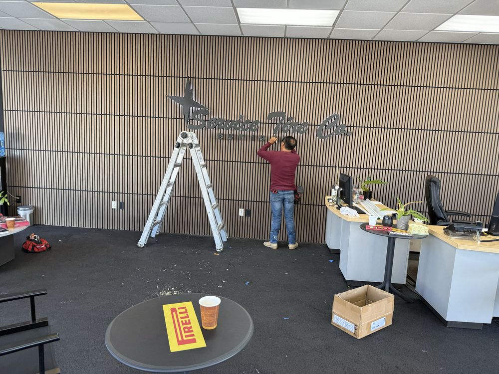 Person installing sign in modern office space.