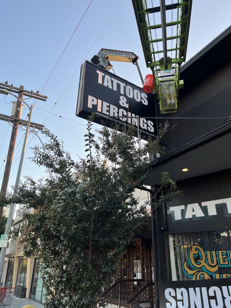 Tattoos and piercings shop sign installation.