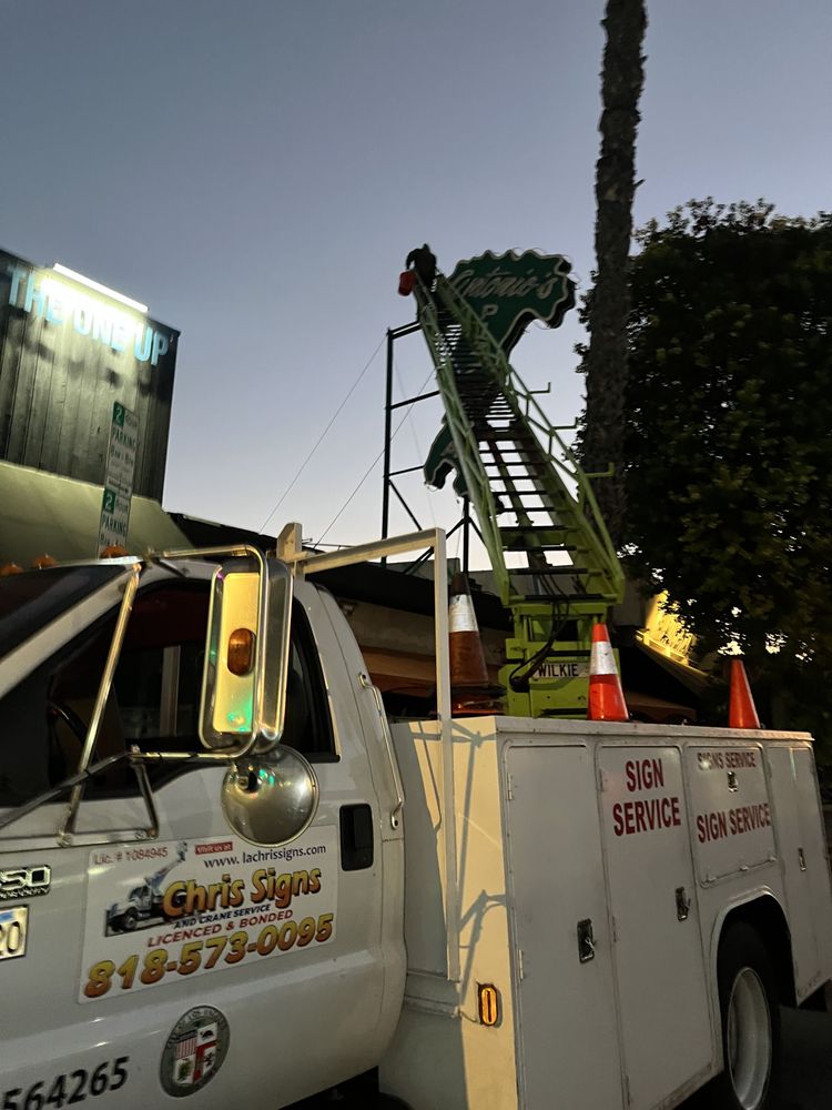 Truck with ladder for sign installation work.