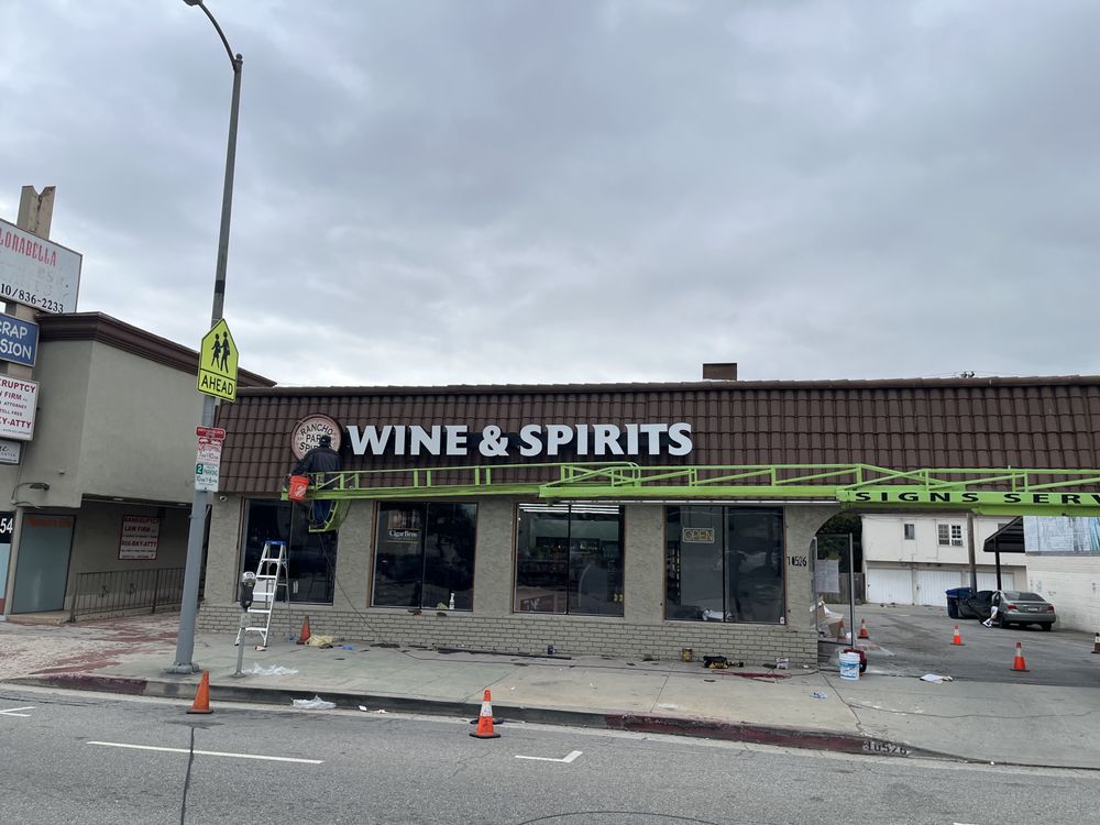 Storefront with "Wine & Spirits" sign installation.