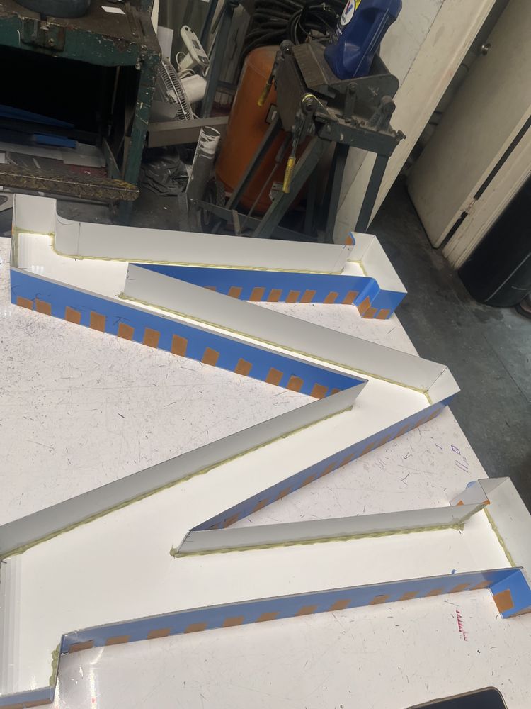 Large letter "M" sign in workshop.