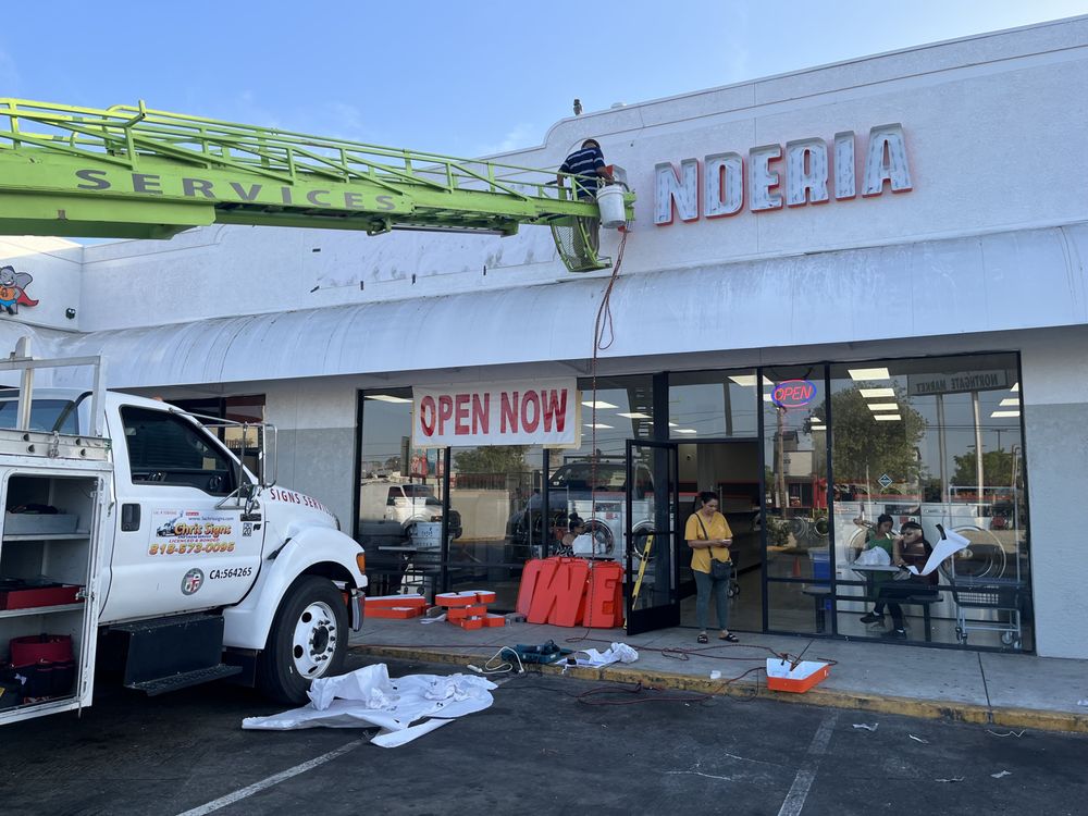 Storefront with sign installation in progress.