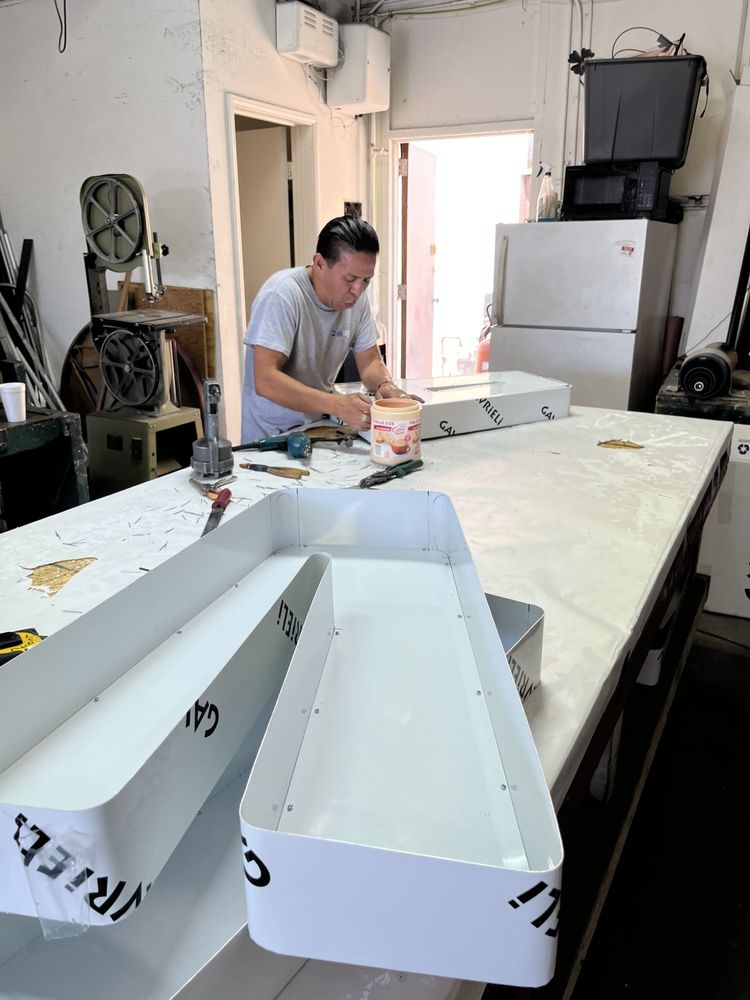 Person working on sign in workshop.