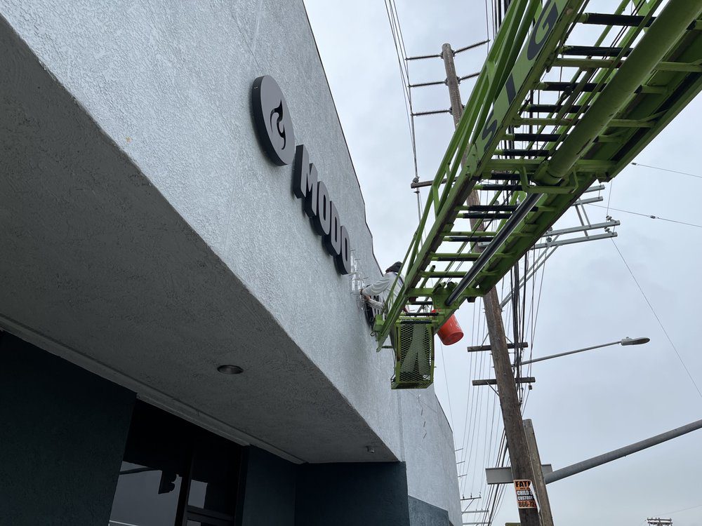 Sign installation on building with green lift.