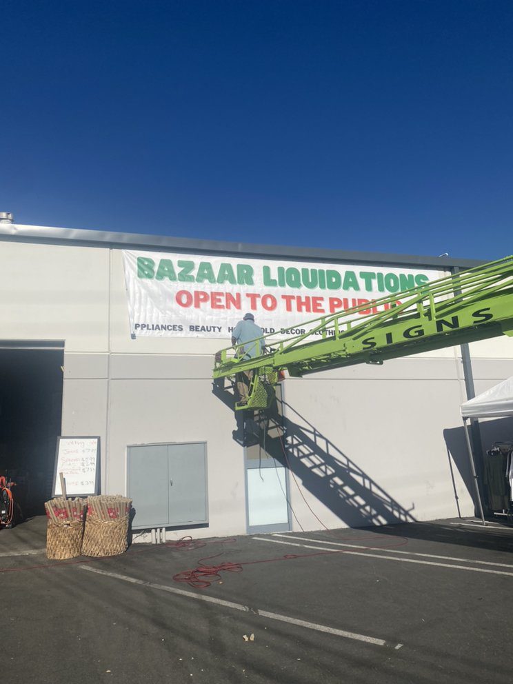 Sign installation for bazaar liquidations event.