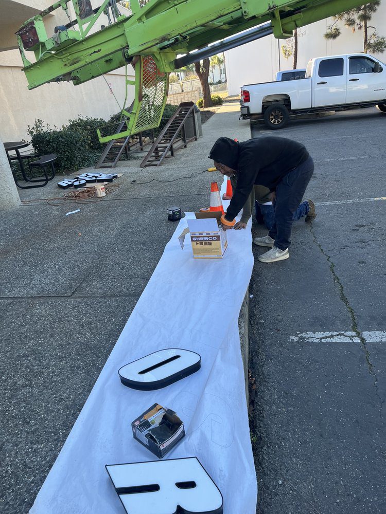Workers preparing letters for sign installation.