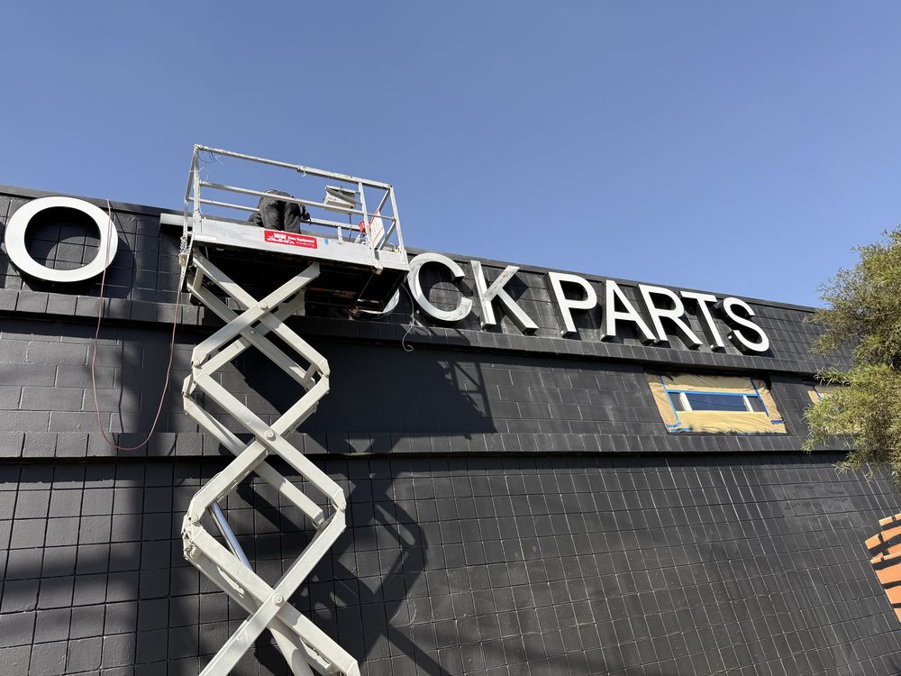 Sign installation on building using lift platform.