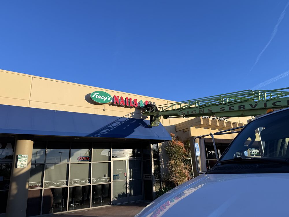 Nail salon sign installation in progress.