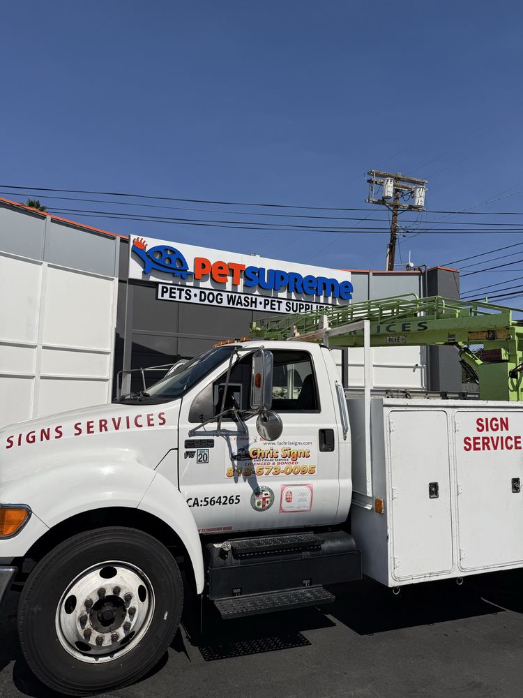 Truck near pet store sign installation.