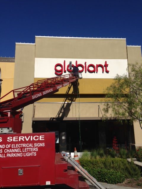 Sign installation on building with cherry picker.