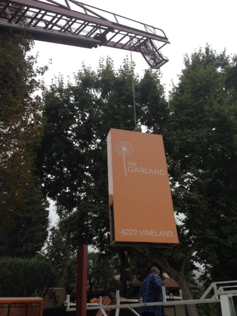 Crane lifting "The Garland" sign installation.