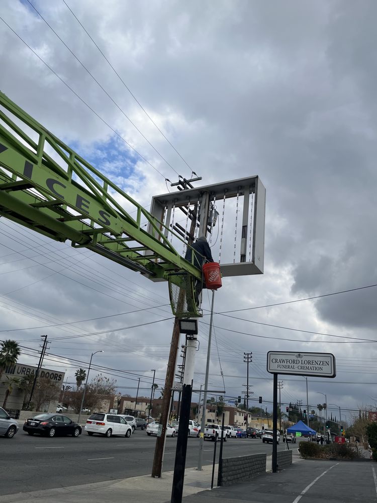 Worker on lift near street sign installation.
