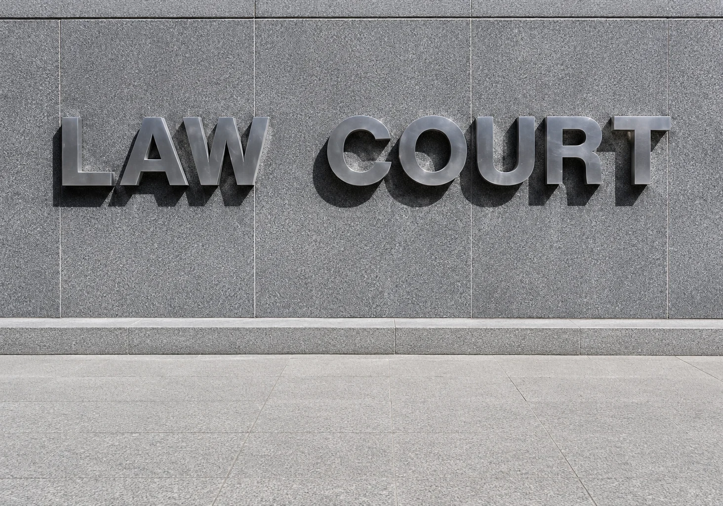 Law court sign on gray stone wall.