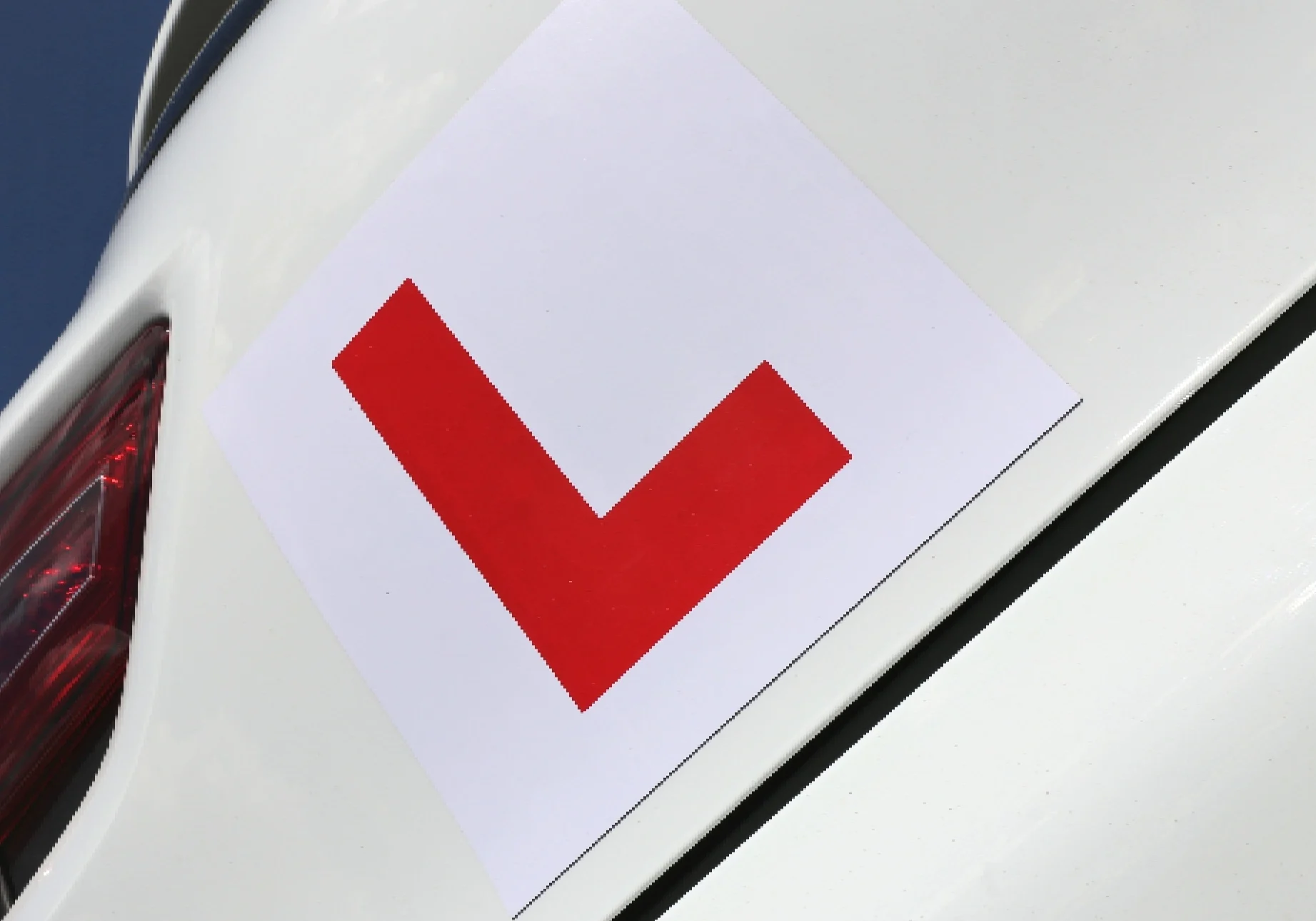 White car with red L plate.