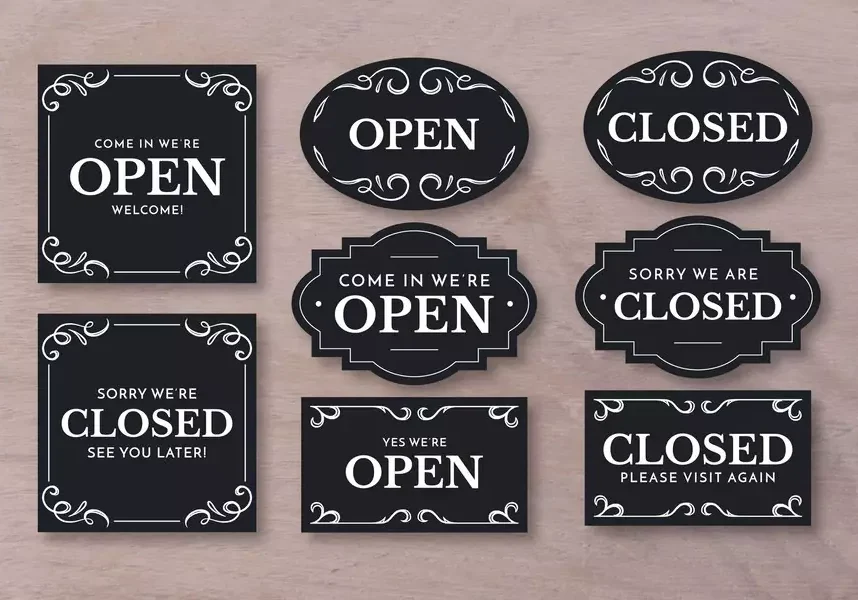 Black open and closed signs with decorative borders.