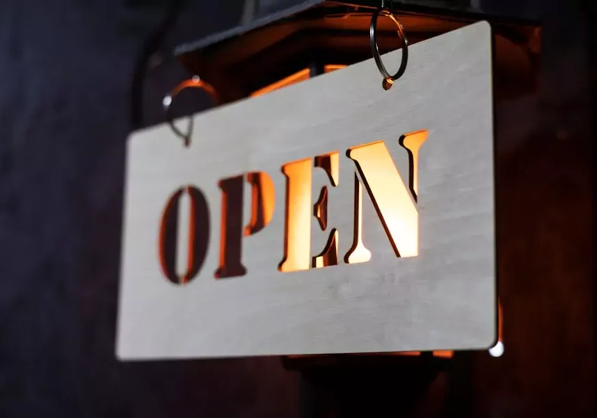 Open sign hanging on lit lantern.